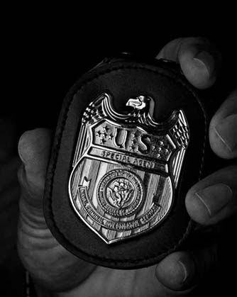 A hand holds a private detective badge
